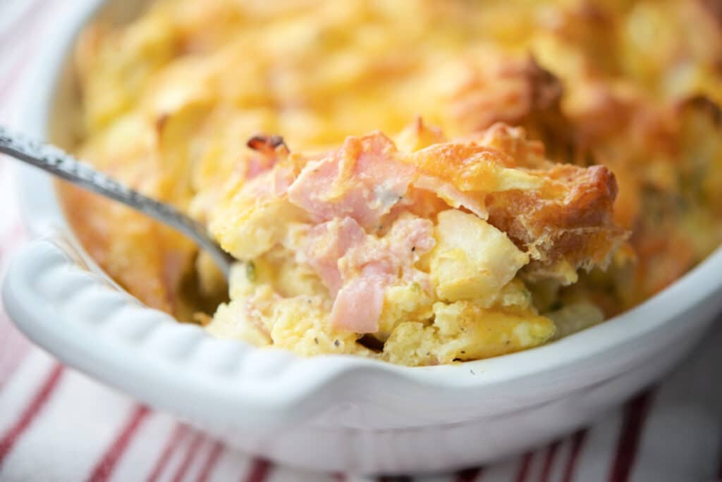 A close up of a breakfast casserole on a spoon