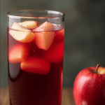 a tall glass of red apple sangria
