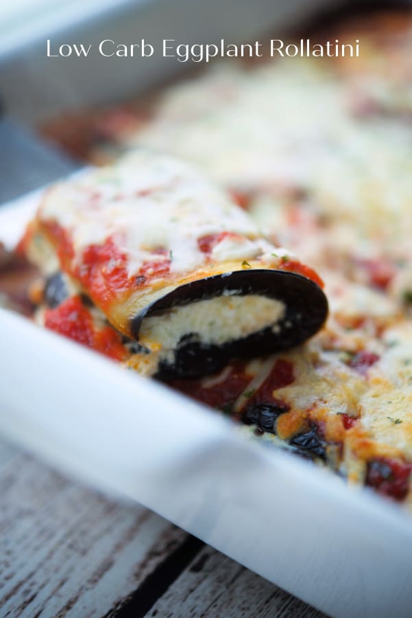 Eggplant rolled up with ricotta cheese in a white dish.