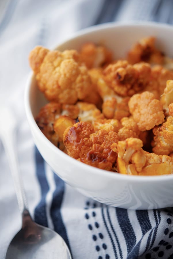 Roasted cauliflower in a bowl with buffalo sauce