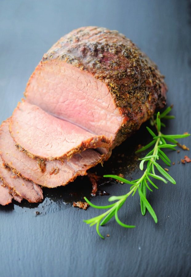 roast beef sliced on a gray board