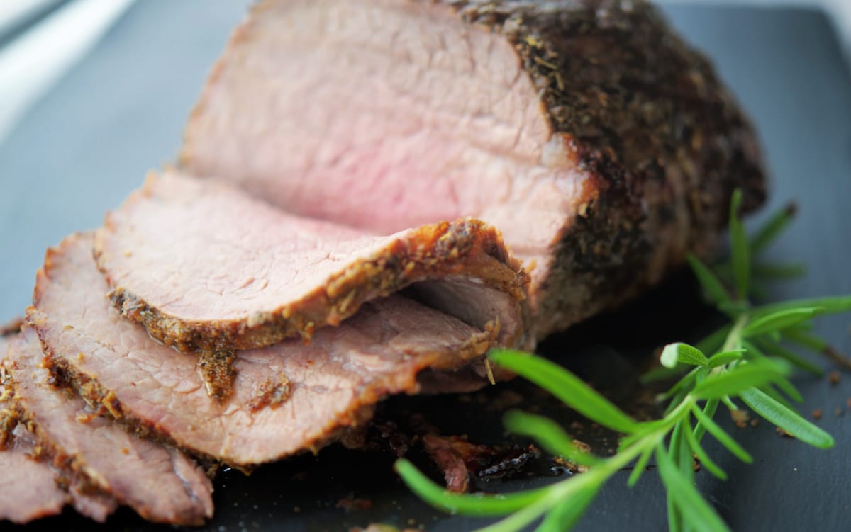 a close up of sliced beef on a board