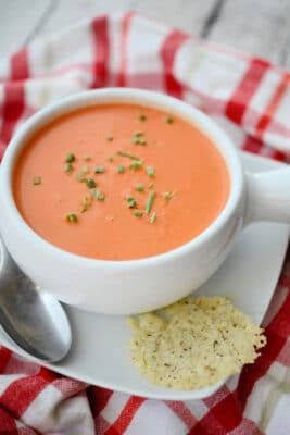 tomato soup in a white crock with a spoon