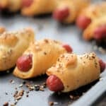 a close up of pigs in a blanket on a sheet pan