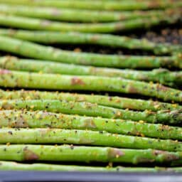 a close up of roasted asparagus with lemon pepper seasoning