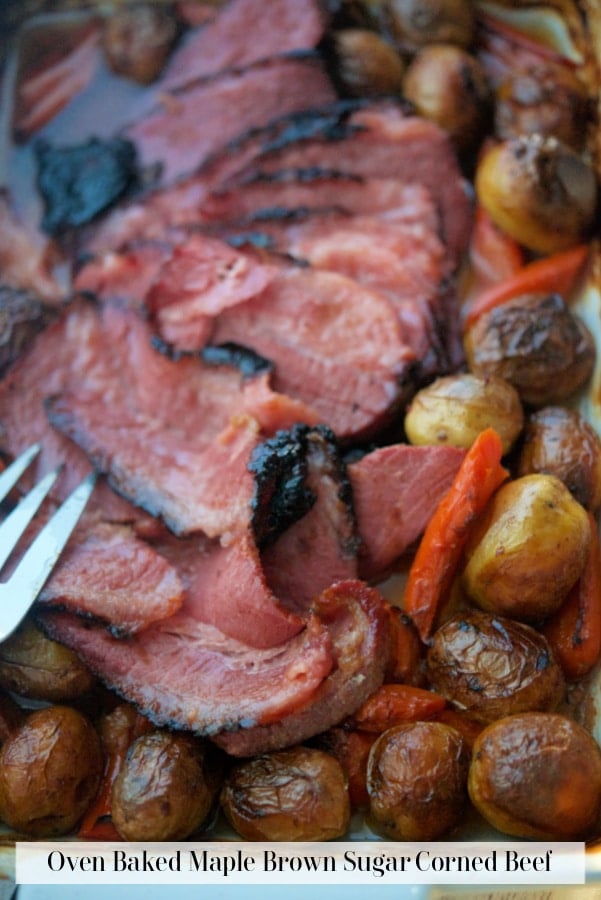 sliced corned beef in a pan with potatoes and carrots