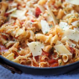 campanelle pasta in a skillet with mushrooms and tomatoes