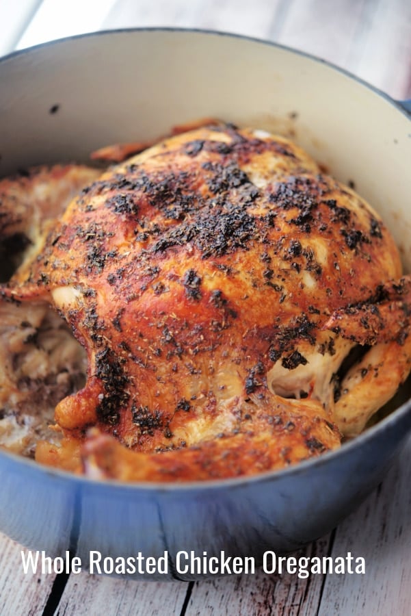 a whole chicken in a blue dutch oven