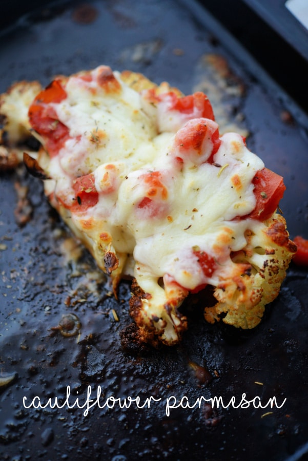 a thick slice of cauliflower with tomatoes and cheese
