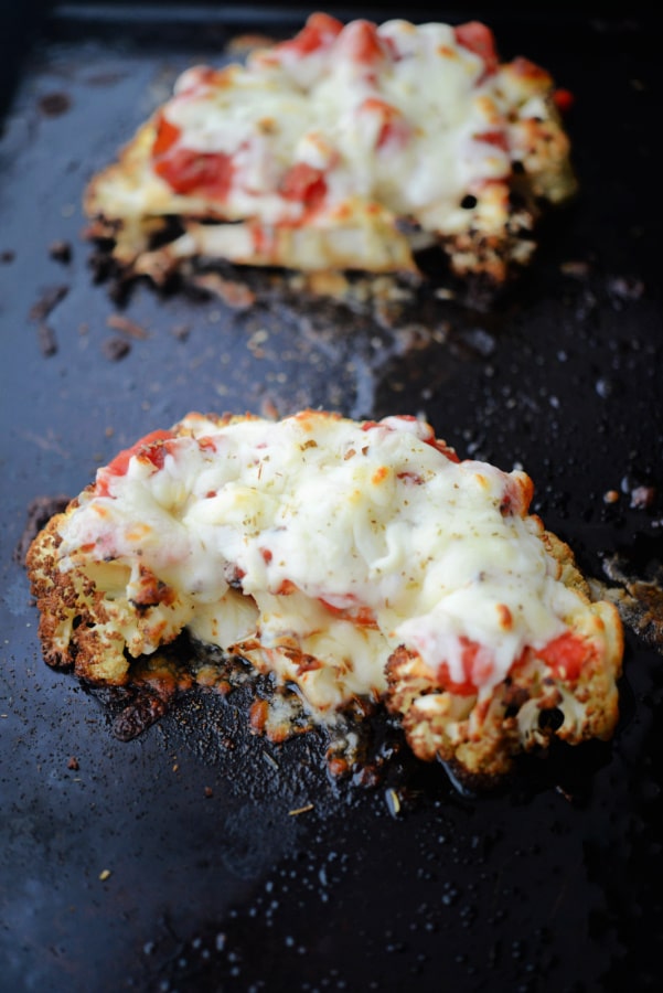 two roasted cauliflower parmesan on a sheet pan