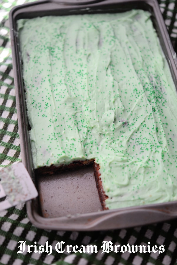 chocolate brownies in a pan with green frosting