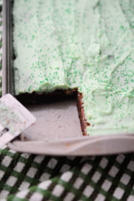 brownies in a pan with green irish cream frosting