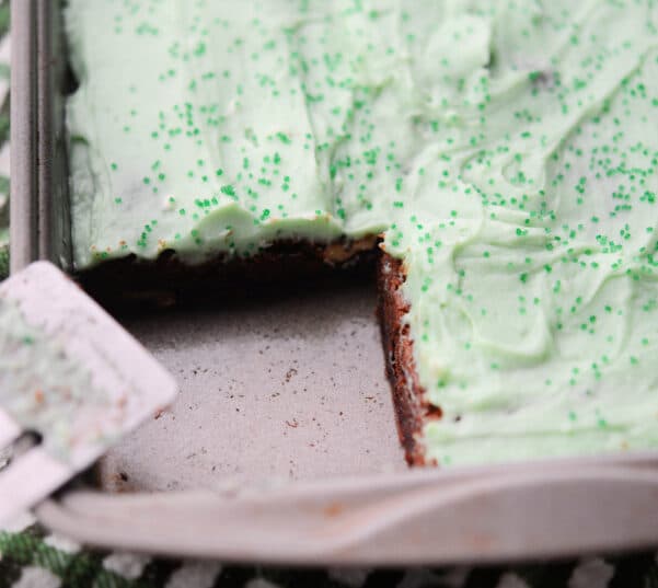 brownies in a pan with green irish cream frosting