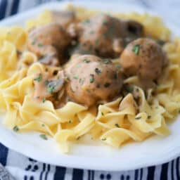 a close up of chicken meatballs on top of noodles