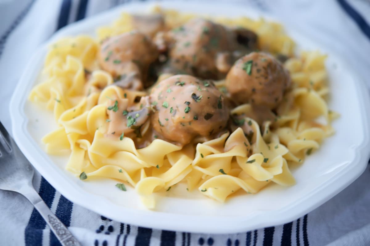 a close up of chicken meatballs on top of noodles