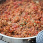 a close up of sauce with sausage in a pan