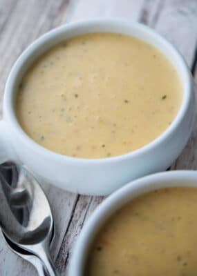 creamy corn tomato chowder in a white soup crock with spoons