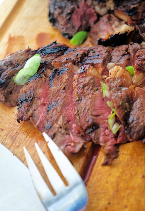 sliced rib eye steak on a wooden board