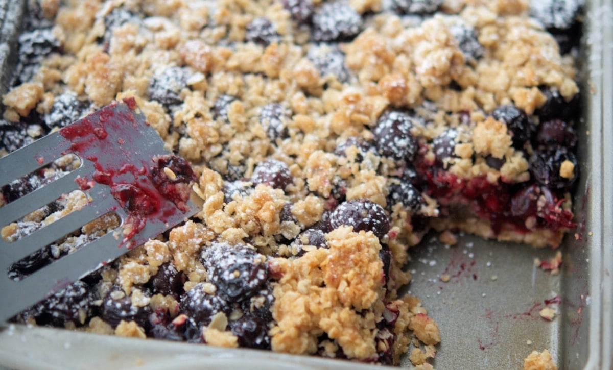 a close up of crumb bars with blueberries in a pan