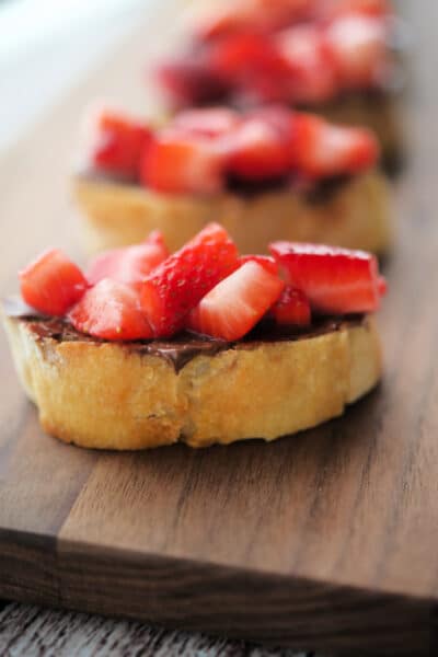 strawberry crostini on a wood board