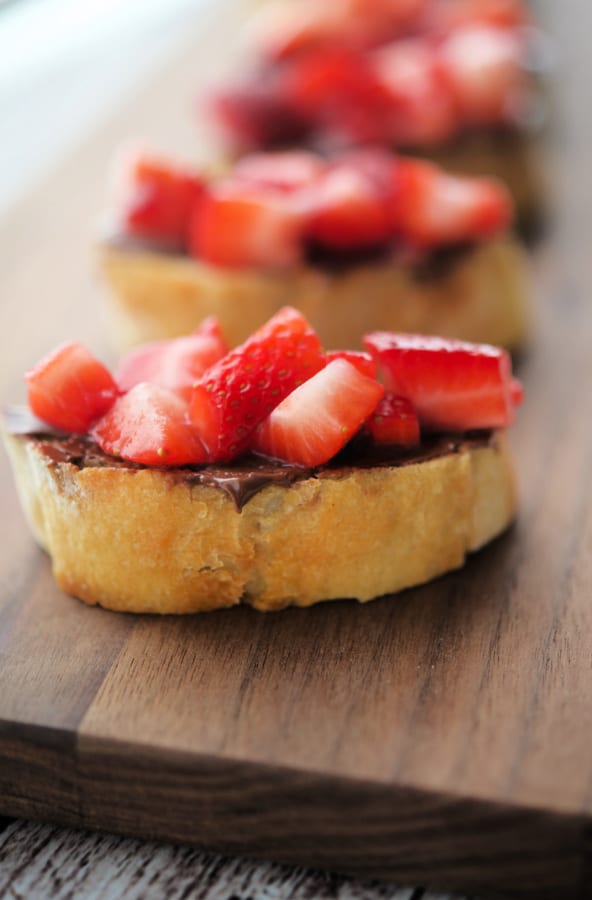 strawberry crostini on a wood board