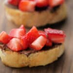 a close up of strawberries and hazelnut spread on bread