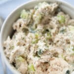 chicken salad made with tzatziki in a white bowl on a napkin with a spoon
