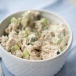 a close up of chicken salad in a white bowl