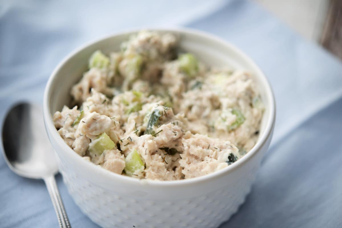 a close up of chicken salad in a white bowl