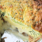 a whole broccoli quiche in a pie plate with a piece cut out