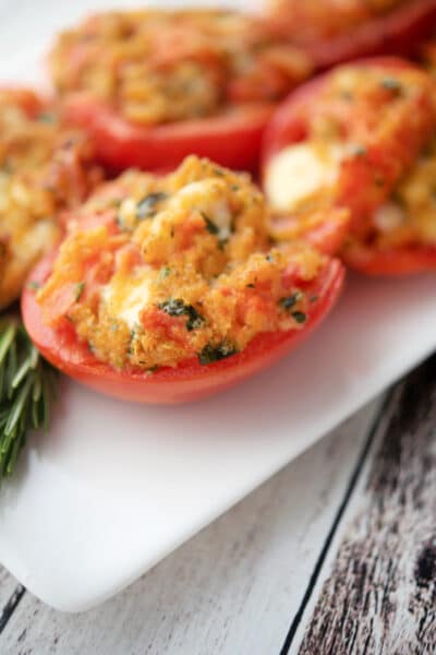 roma tomatoes stuffed with cheese on a plate