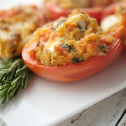 a close up of tomatoes on a plate with fontina cheese
