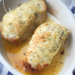 two pork chops crusted with parmesan cheese in a white baking dish