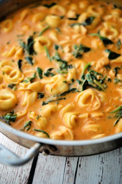 tortellini, chicken and spinach in a skillet