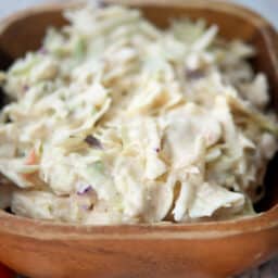 a close up of coleslaw in a wooden bowl