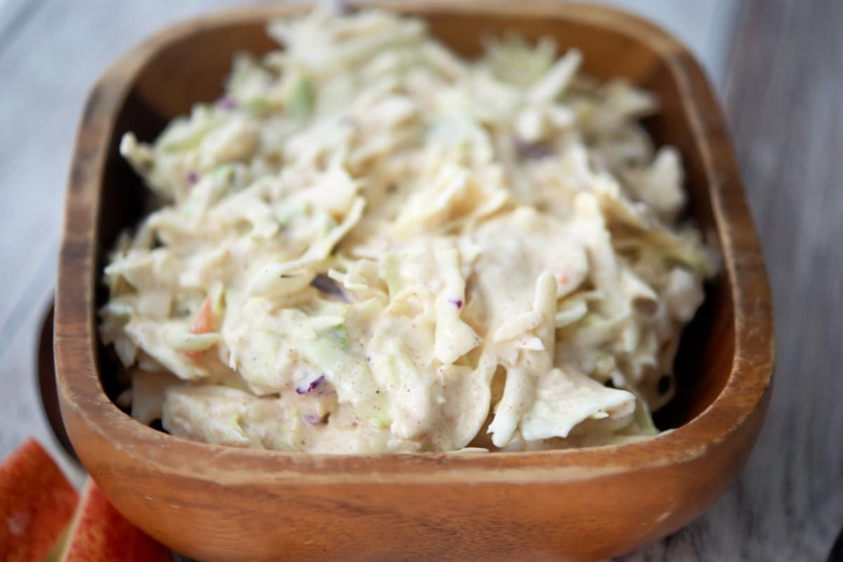 a close up of coleslaw in a wooden bowl