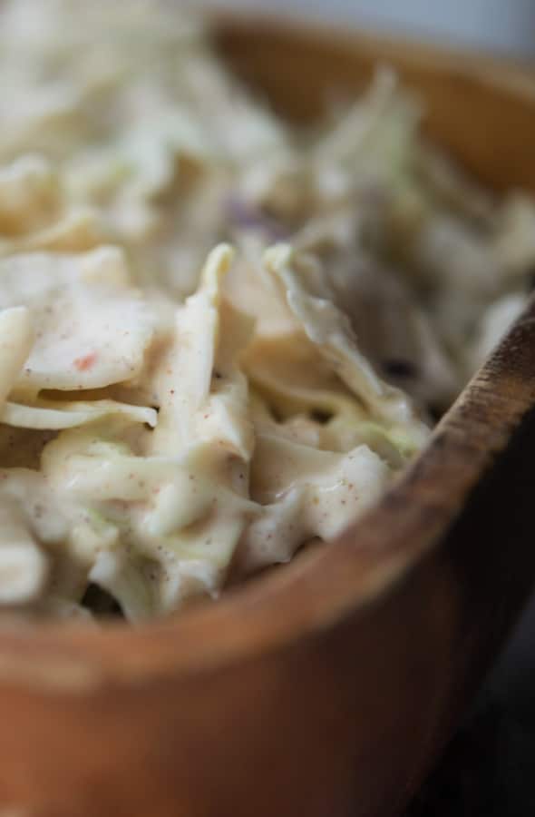 a close up of apple slaw in a wooden bowl