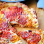 a slice cut out of a deep dish pizza with roasted tomatoes