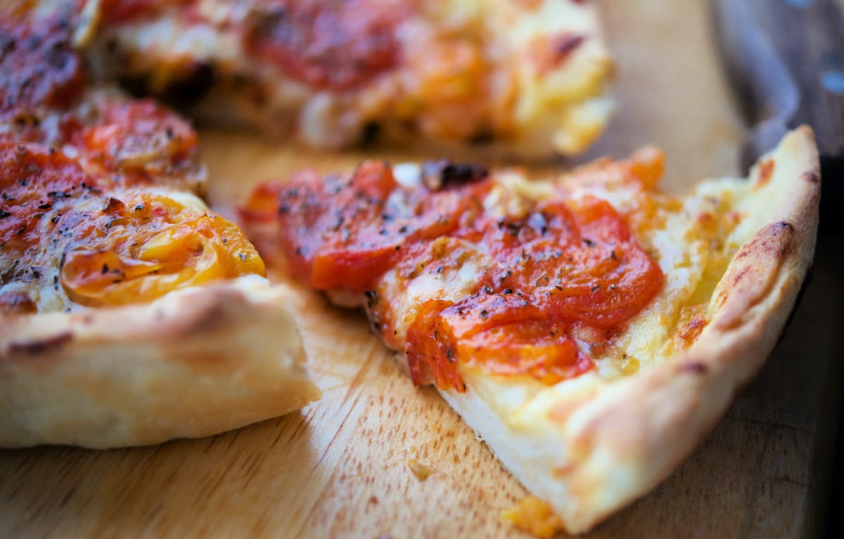 a slice of deep dish pizza on a cutting board