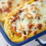 a close up of two squashes in a dish with cheese