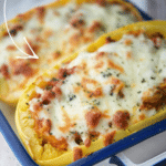 spaghetti squash in a blue and white dish stuffed with sausage bolognese