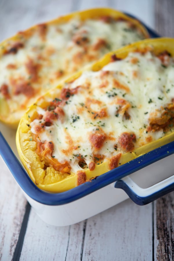 sausage bolognese stuffed spaghetti squash in a white and blue dish