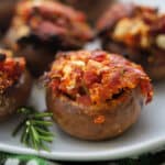 a plate of stuffed mushrooms with goat cheese and tomatoes