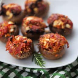 a plate of stuffed mushrooms with sun dried tomatoes
