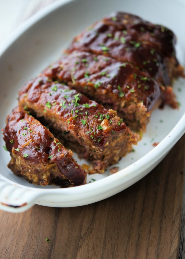 a white baking dish with slices of bbq meatloaf