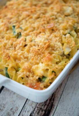 casserole with chicken, vegetables and noodles in a white baking dish