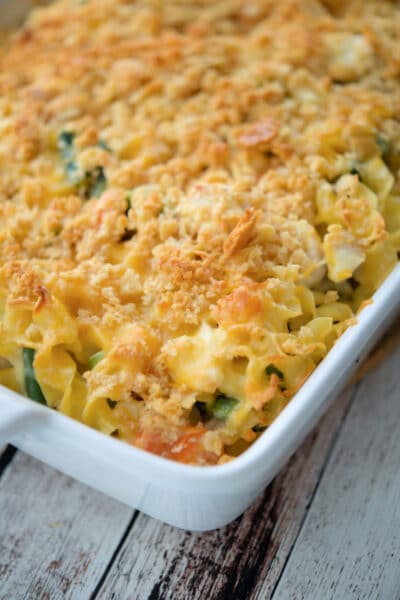 casserole with chicken, vegetables and noodles in a white baking dish