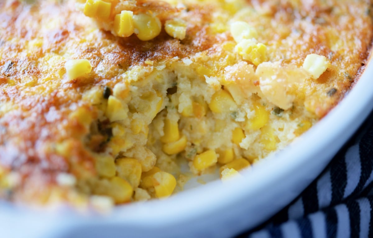 a close up of a baked corn casserole with a spoonful taken out
