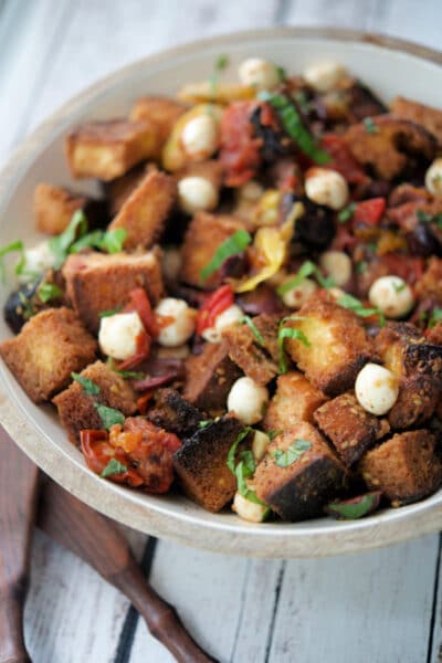 a wooden bowl filled with bread panzanella salad