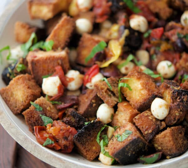 a wooden bowl filled with bread panzanella salad